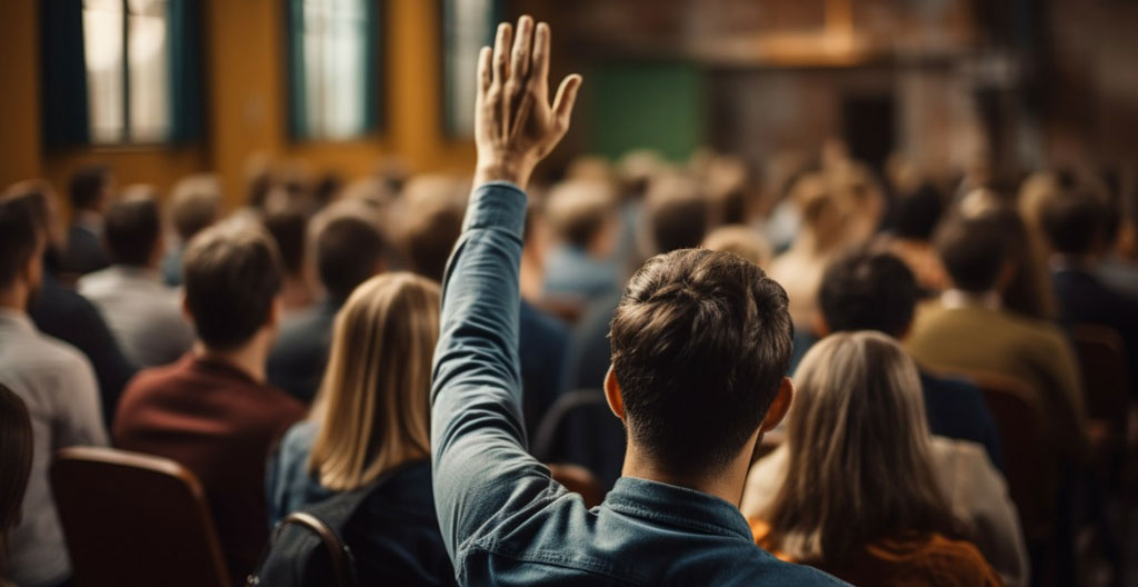 Vue d'ensemble d'une réunion coopérative dans une salle claire, plusieurs personnes levant la main pour voter, ambiance détendue et citoyenne
